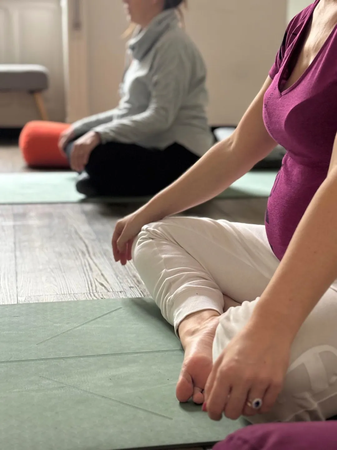 Donna in gravidanza seduta in posizione del loto durante una pratica meditativa