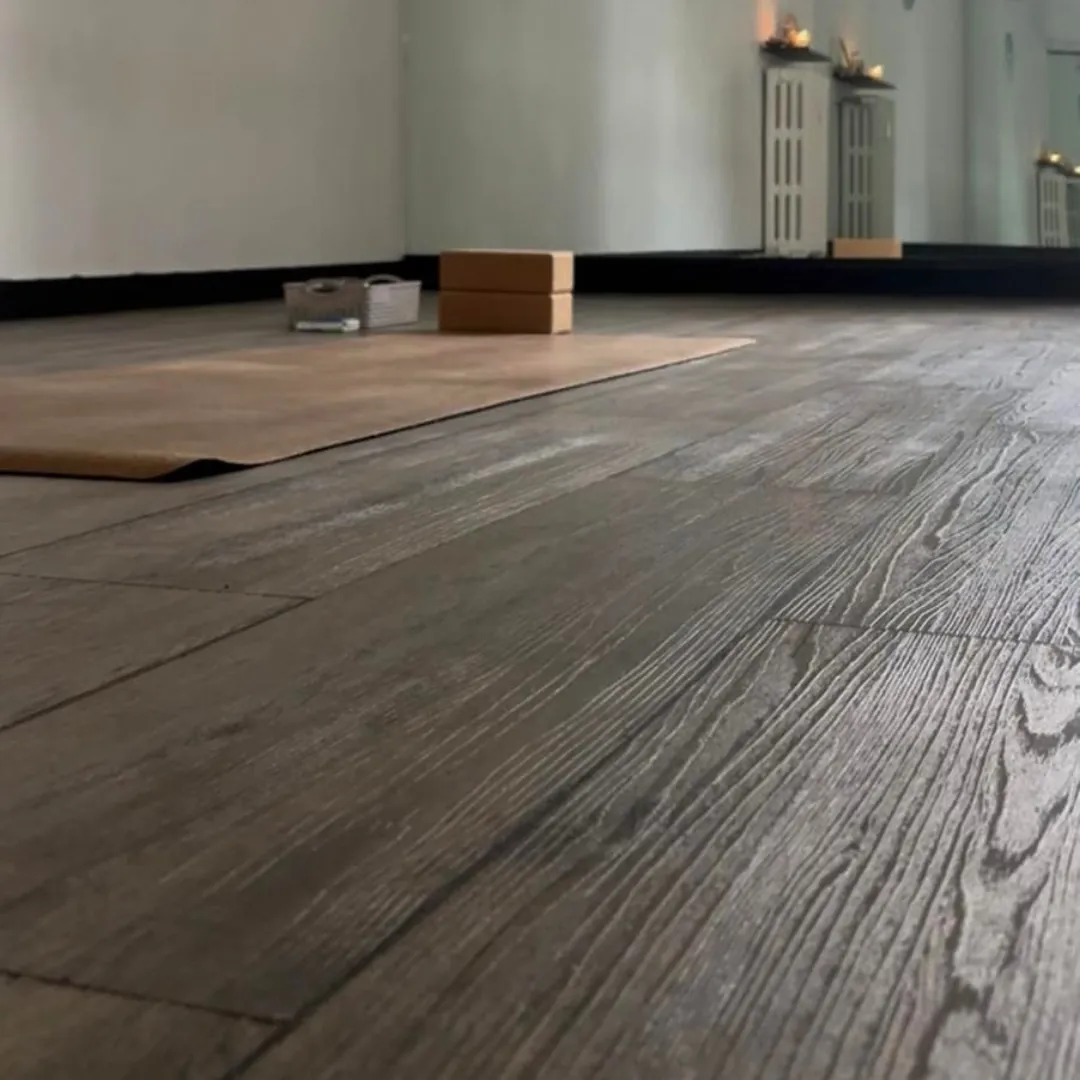 Dettaglio della sala yoga di Genova Carignano: tappetino in juta e blocchi di sughero su parquet